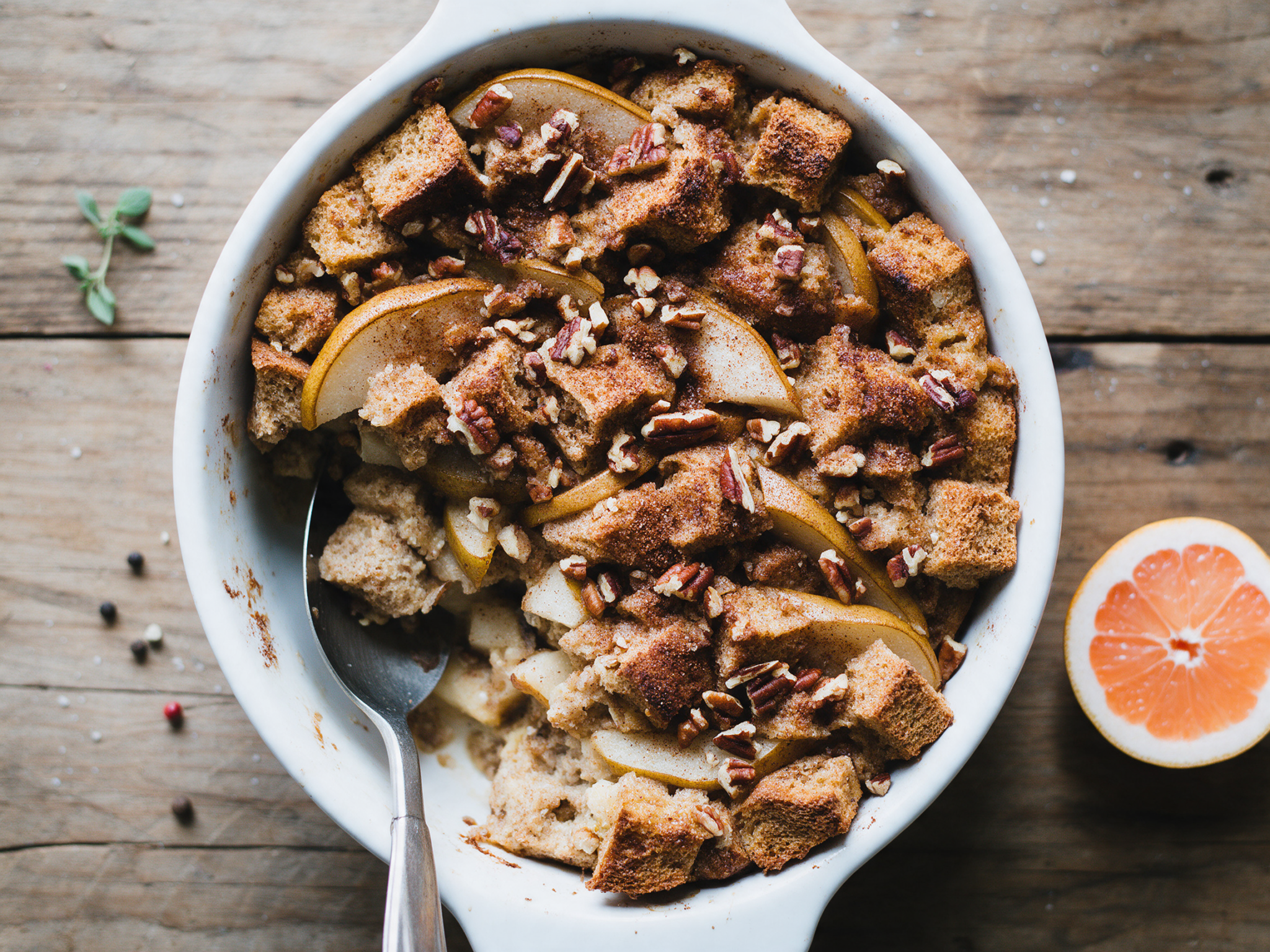 Baked spelt pear French toast casserole with pecans in a white dish