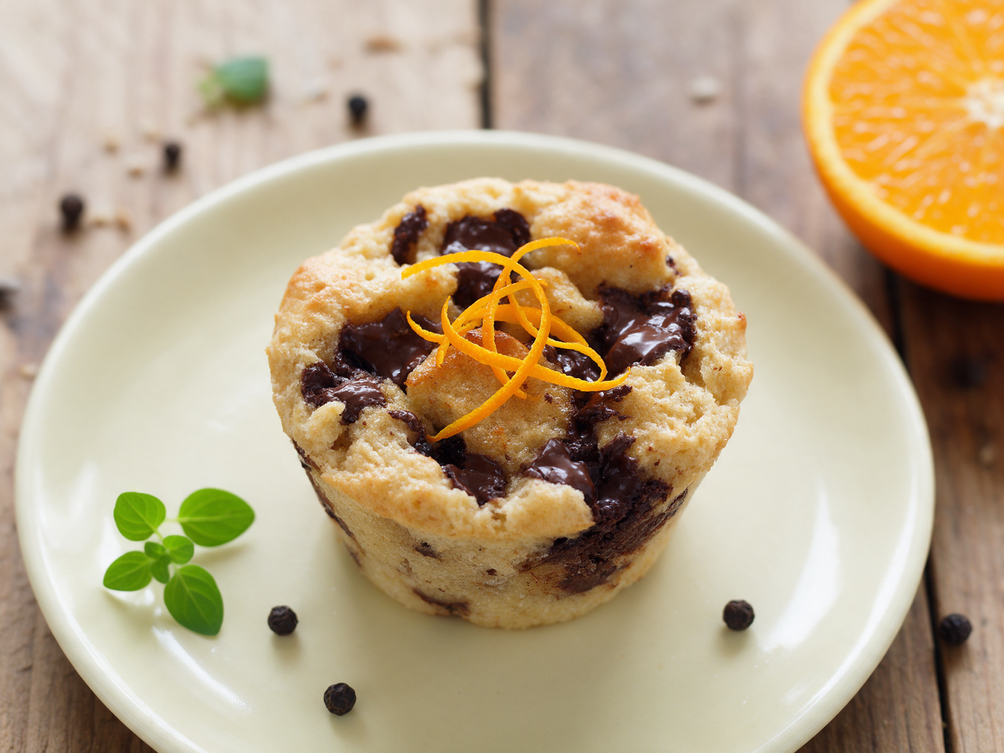 Individual chocolate orange bread pudding cups with orange zest on a plate